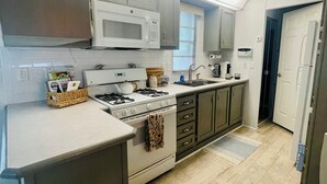 A modern kitchen with a microwave, stove, and cabinets. - The Newly Renovated  Couples  Retreat in Key Largo , Pool  beach , and Marina  (Key Largo)