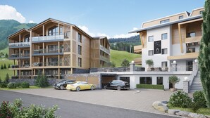 A modern hotel with multiple balconies, a parking area, and a mountainous backdrop. - Premium Suite With Private Sauna (Saalbach-Hinterglemm)