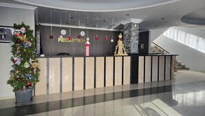A reception area with a Christmas tree, a clock, and a sign that reads "RECEPTION". - Kale Park  (Batumi)