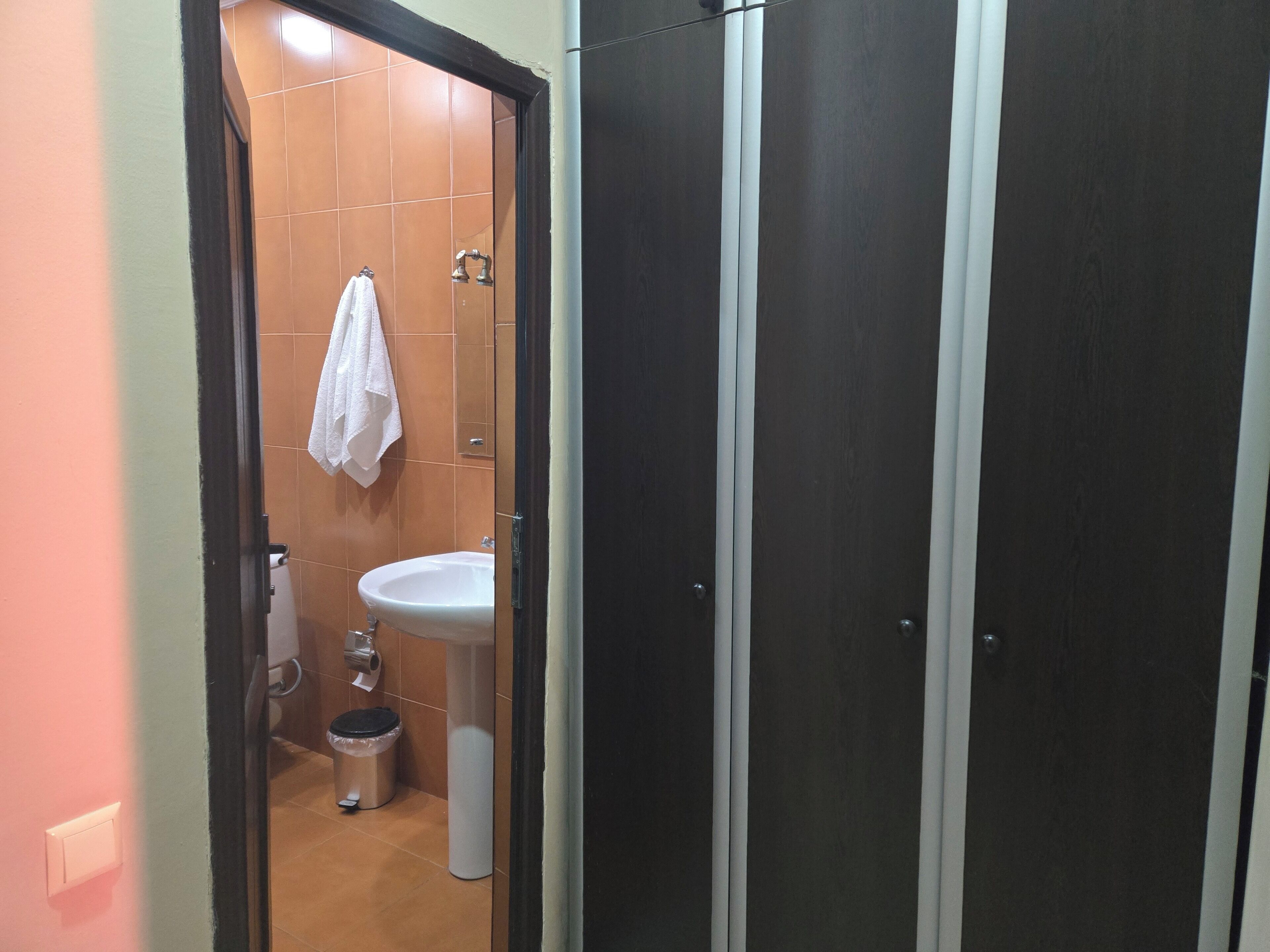 Un baño con lavamanos, inodoro y una toalla colgada en la pared.