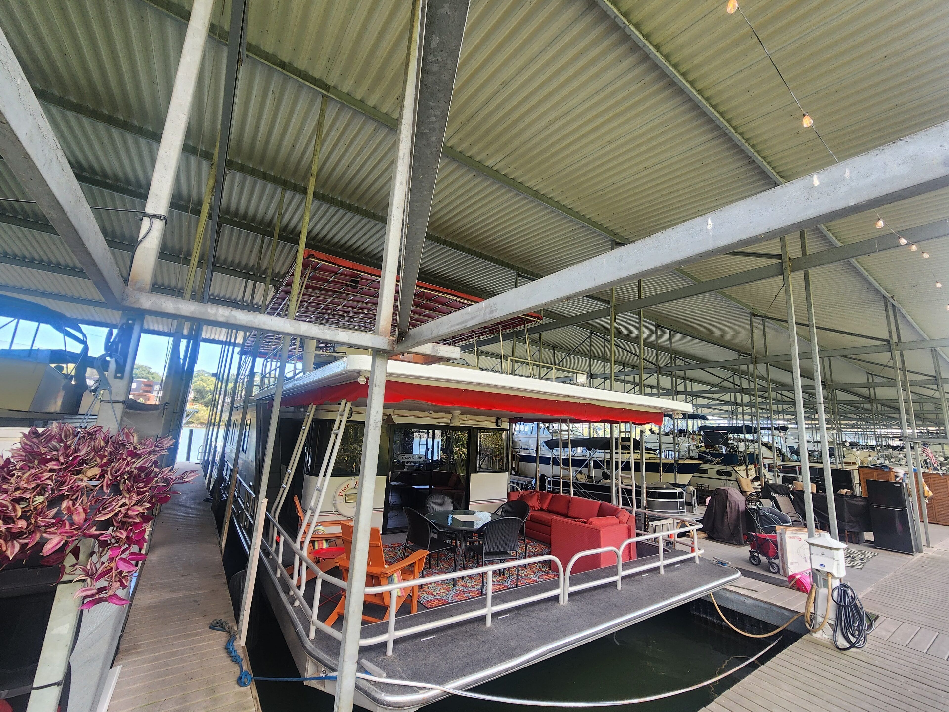 A spacious indoor area with a high ceiling, metal beams, and a covered seating area with a red canopy.