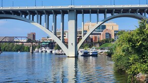 A bridge with a modern design, spanning over a body of water with boats docked below. - Pier D Lite 4 bdrm Houseboat on River Downtown Knoxville - walk to Univ. of TN  (Knoxville)