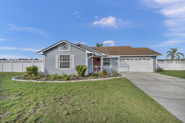 A single-story house with a front porch, a garage, and a well-maintained lawn. - Rose's Lakeview (Orlando)