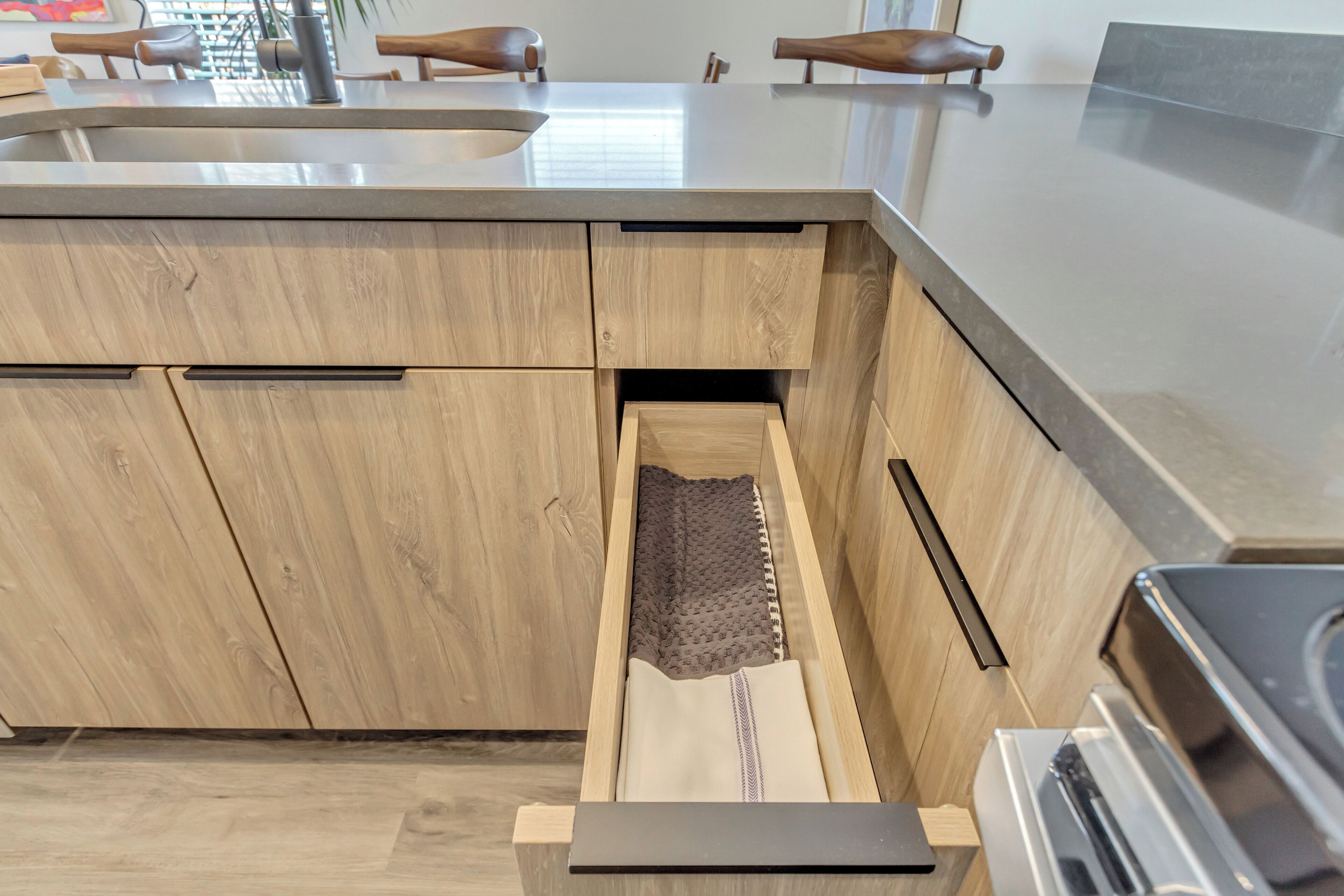 A kitchen with wooden cabinets, a stainless steel sink, and a built-in oven.