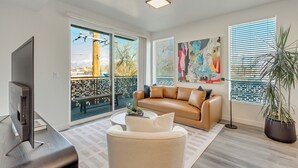 A modern living room with a large window, a sofa, a coffee table, and a TV. - LCF - Sugarhood - Sugar House- 3BR/2BA - CoWork + Gym - 2 Kings + Queen (Salt Lake City)