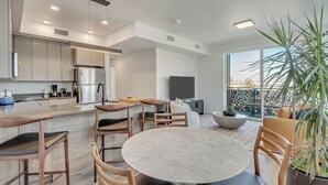 A modern kitchen with a large island, built-in appliances, and a dining area with a round table and chairs. - LCF - Sugarhood - Sugar House- 3BR/2BA - CoWork + Gym - 2 Kings + Queen (Salt Lake City)