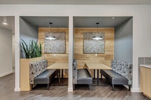 Un espace repas moderne avec deux banquettes, des murs en bois et des luminaires suspendus.