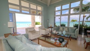 Ein geräumiges Wohnzimmer mit großen Fenstern und Meerblick.