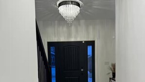 A hallway with a black door, a staircase, and a chandelier. - new house. built in 2022

 (Stratford)