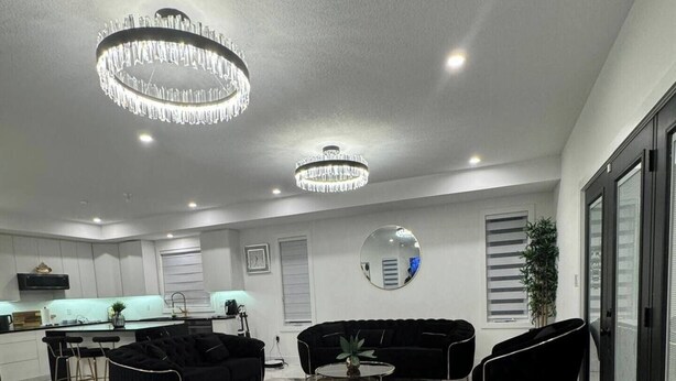 A modern living room with a black sofa, two armchairs, a coffee table, and a chandelier. - new house. built in 2022

 (Stratford)