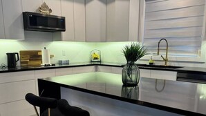 A modern kitchen with a central island, bar stools, a microwave, and a sink. - new house. built in 2022

 (Stratford)
