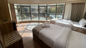 A hotel room with two beds, a wooden desk, and large windows offering a view of the outdoors. - Golden Season Hotel  (Cairo)