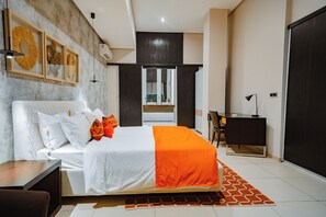 A modern bedroom with a large bed, a desk, and a wardrobe. - La Résidence Sea Plaza (Dakar)
