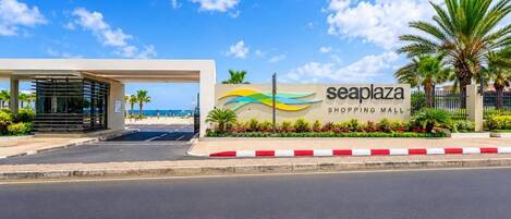 A shopping mall entrance with a sign reading 'seaplaza shopping mall' and a covered walkway.