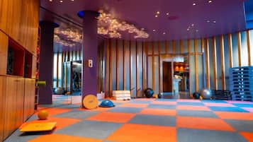 A gym with exercise equipment, a checkered floor, and a wooden wall.