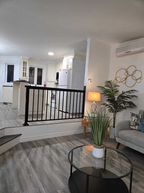 A modern apartment with a living room, kitchen, and balcony. - Villa Des Petits Bonheurs (Chénéville)