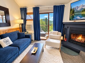 A modern living room with a fireplace, a sofa, a chair, and a coffee table. - Lutsen Ski-In/Ski-Out | Moose Mtn Views | Jet Spa (Lutsen)