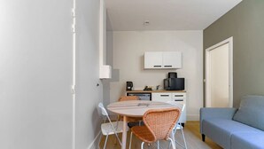 Un espacio habitable compacto con comedor, kitchenette y sofá.