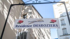 Señal para 'Résidence DESROZIERS' con un mensaje de bienvenida e ilustración de una rosa.