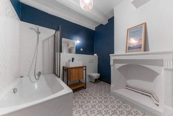Un baño con bañera, lavamanos e inodoro.