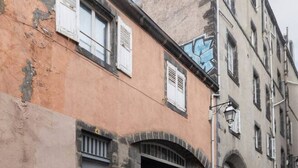 A narrow street with old buildings, one with a visible door and window shutters, and another with a visible arched entrance. - Le Paradis - 4 rue du Paradis - Clermont (Clermont-Ferrand)