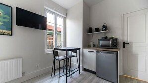 A compact kitchen with a dining area, a built-in microwave, and a dishwasher. - Le Desroziers 312 - 31 avenue Victoria - Vichy (Vichy)