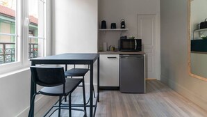 A compact kitchen with a dining table and chairs, a microwave, and a dishwasher. - Le Desroziers 312 - 31 avenue Victoria - Vichy (Vichy)