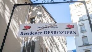 Señal para 'Résidence DESROZIERS' con un mensaje de bienvenida e ilustración de una rosa.