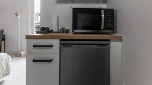A compact kitchenette with a microwave, coffee maker, and a small refrigerator.