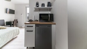 A compact kitchenette with a microwave, coffee maker, and a dishwasher.
