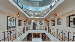 A multi-level atrium with a central staircase, railings, and ceiling views.