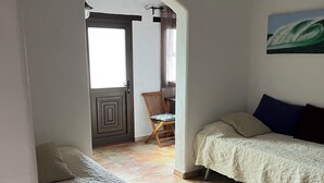 Een kamer met een bed, een stoel en een schilderij aan de muur.