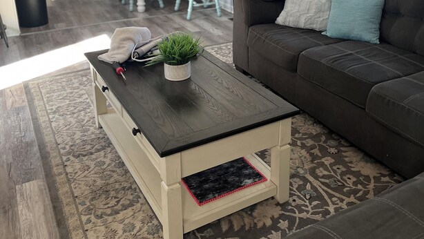 Una sala de estar moderna con un sofá marrón oscuro, una mesa de centro con una planta y un comedor con una mesa y sillas de madera.