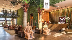 A modern lobby with a reception desk, two large terracotta warrior statues, and a green wall with vertical wooden slats. - Stay Near Disney Magic | Gorgeous 4BR Villa w BBQ (Kissimmee)