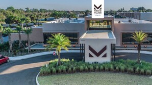 A modern building with a large sign reading "MAGIC VILLAGE Views". - Stay Near Disney Magic | Gorgeous 4BR Villa w BBQ (Kissimmee)