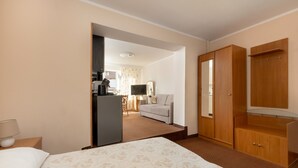 Una camera d'albergo con un letto, una scrivania con un computer, una televisione e un armadio.