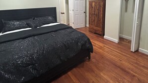 A bedroom with a bed, a ceiling fan, a wardrobe, and a walk-in closet.