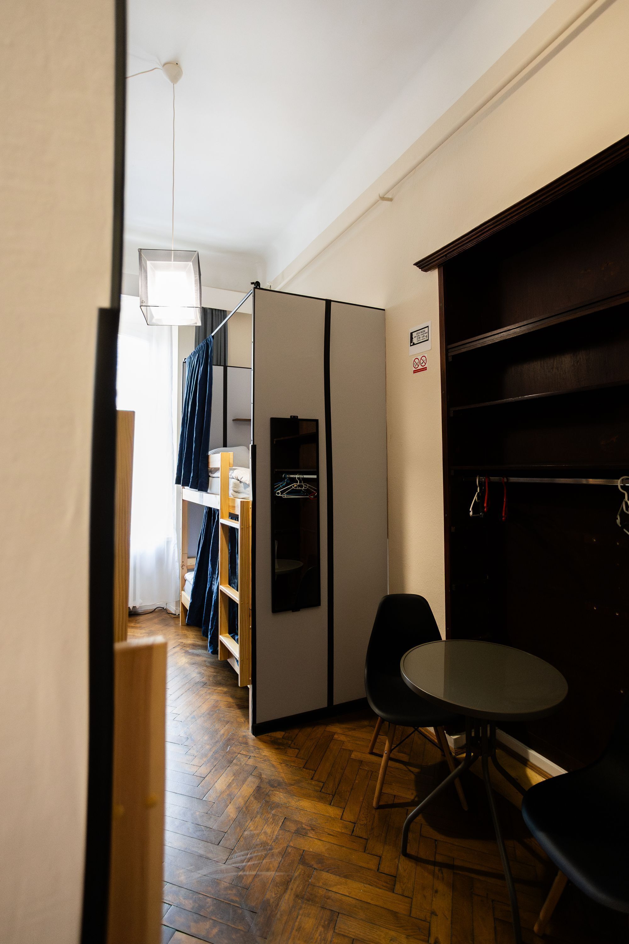 Una habitación funcional con kitchenette, una mesa de comedor y sillas, y un armario.