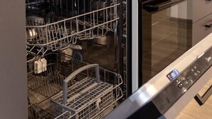 A modern kitchen with a dishwasher, oven, and a wooden countertop. - Urban Chic Luxury Suite Apartments (Roma)