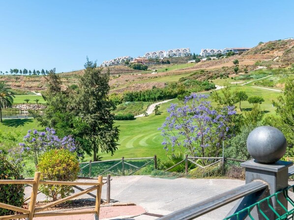 Un parcours de golf offrant une vue sur des immeubles résidentiels en arrière-plan.
