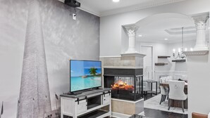 A modern living room with a fireplace, a television, and a dining area. - 3 DC Homes | Sleeps 30 | Group Getaway (Washington)