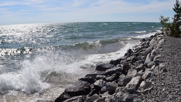 Una costa rocosa con olas rompiendo contra las rocas.