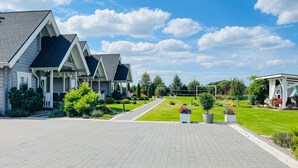 A residential area with multiple houses, a well-maintained lawn, and a paved driveway. - Stunning home in Sarbinowo with WiFi (Sarbinowo)