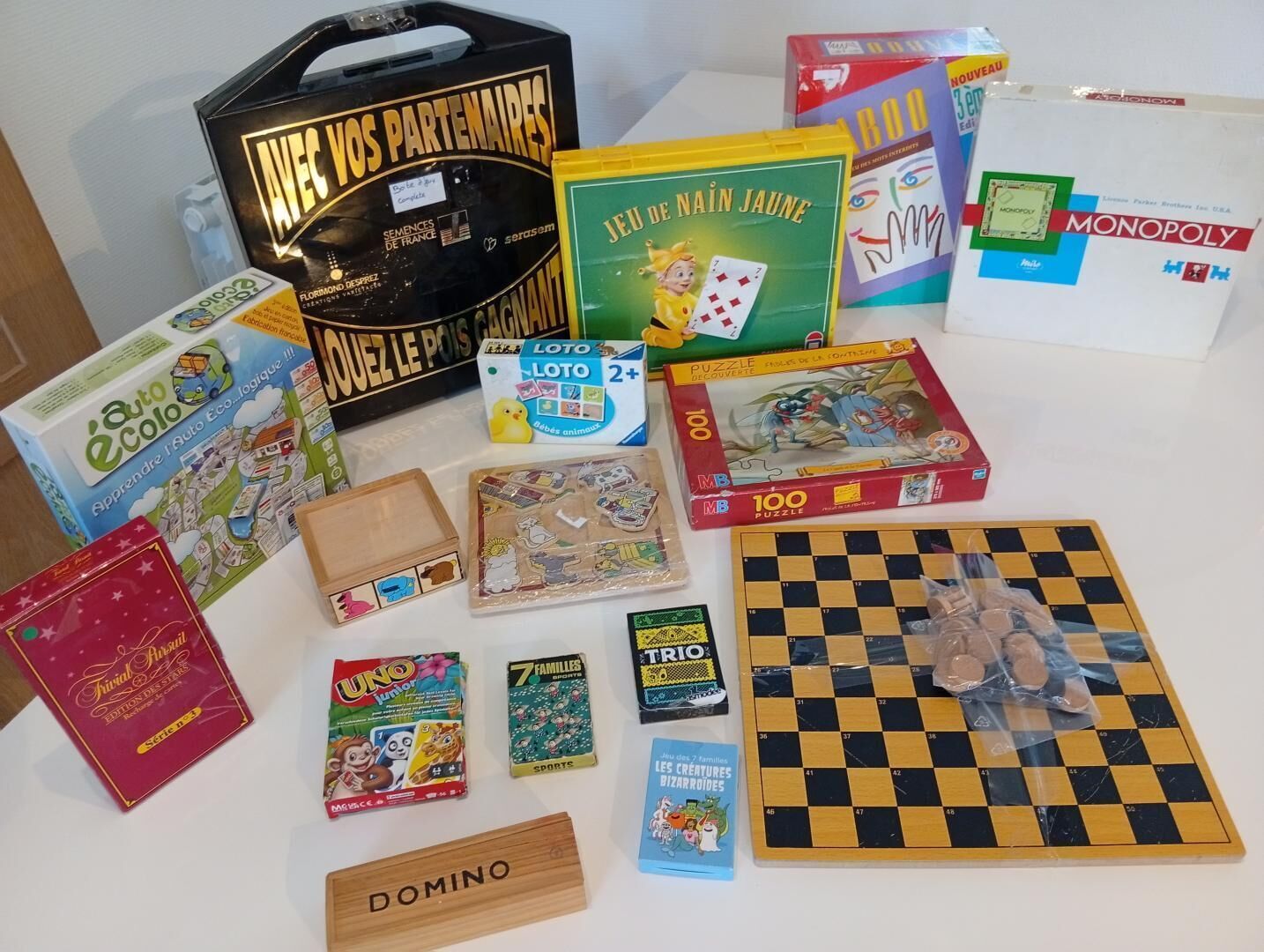 Une variété de jeux de société et de casse-têtes sont disposés sur une table.