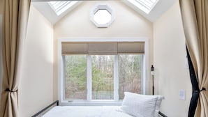 Una camera da letto con un'ampia finestra, un letto e un velux.