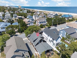 A residential area with houses, a beach, and a clear sky.