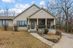 Stunning two-story residence with a central entrance, double doors, and a charming porch area.