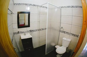 A bathroom with a toilet, sink, and mirror. - Fully equipped cabins for up to 6 people. Surrounded by nature.  (Puerto Iguazú)