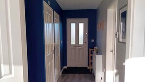 A hallway with a wooden floor, white doors, and blue walls. - Elysian Escape, modern 5 bedroom house, sleeps 12 (Darlington)