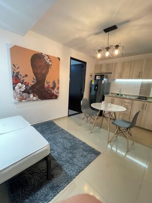 A modern kitchen with a built-in oven, a refrigerator, and a dining area with a table and chairs. - Luxury Liv Limonar (Cali)